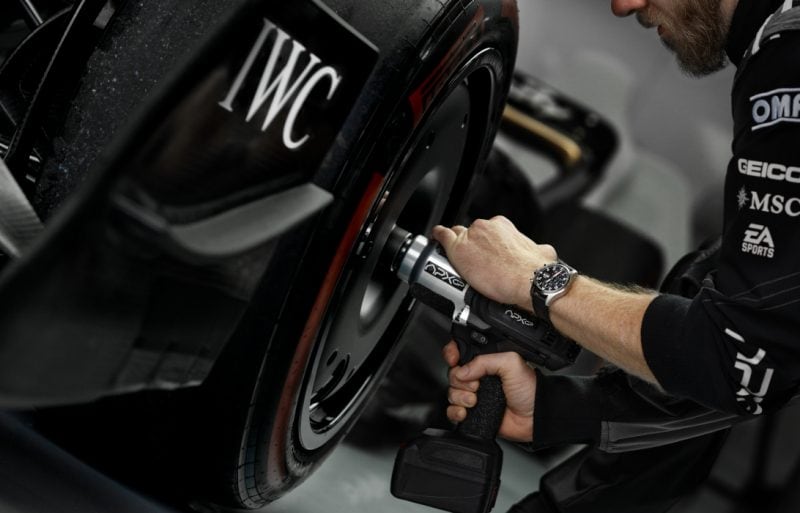 Closeup shot of a wheel gun operator’s wrist changing tires of a formula one car.,Closeup shot of a wheel gun operator’s wrist changing tires of a formula one car.